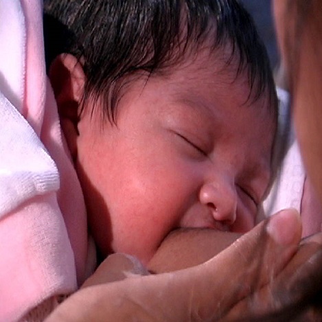 Recién nacido apegado adecuadamente a la mama, con la boca abierta cubriendo la areola. 